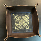 Decorative tray with gold emblem on a dark surface