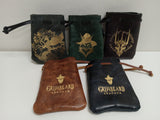 Collection of leather pouches with engraved designs and 'Griabeard Leather' branding on a white surface.