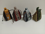 Four small leather bags with different patterns and colors on a white background