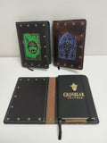 Three leather-bound books with decorative covers on a white surface.