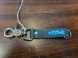 Keychain with blue logo on a wooden surface