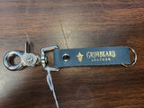 Grimbeard Leather keychain on a wooden surface