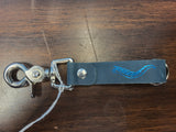 Blue leather keychain with metal clasp on a wooden surface