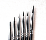 Set of black and silver makeup brushes on a white background