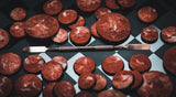 Red velvet cookies on a checkered surface with a knife