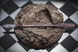 Moldy bread with a knife on a checkered background