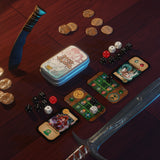 Board game components including cards, dice, and a container on a wooden surface.