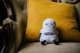 White ghost plush toy with text on a yellow cushion