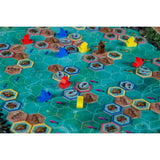 Board game with hexagonal tiles and colorful player pieces on a green board.
