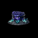 Decorative item resembling a blue and green coral with purple accents on a black background