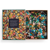 Jigsaw puzzle with colorful pieces and a floral-patterned box on a white background