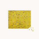 Jigsaw puzzle with yellow emoji pieces on a white background