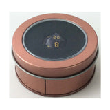 Polyhedral dice with numbers inside a round brown tin on a white background