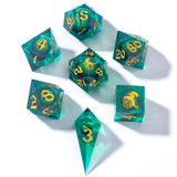 Set of teal polyhedral dice with gold numbers on a white background