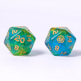 Two polyhedral dice with green and blue glittery finish and gold numbers on a white background