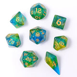 Set of green and blue dice with gold numbers on a white background