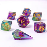 Set of colorful polyhedral dice with gold numbers on a white background