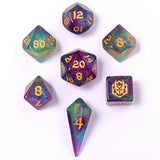 Set of colorful polyhedral dice with gold numbers on a white background