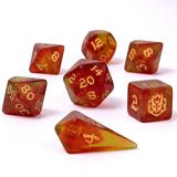 Set of red and gold polyhedral dice on a white background