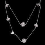 Silver necklace with geometric pendants on a black background