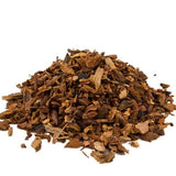 Heap of dried brown herbs or spices on a white background