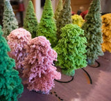 Colorful knitted or crocheted trees on a flat surface
