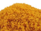 Close-up of a pile of yellow powder on a white background