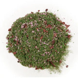 Green powder with red and white specks on a white background