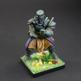 Miniature figurine of a warrior in armor on a grassy base with a dark background