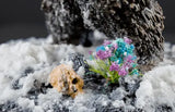 Decorative miniature plant and rock on a snowy surface