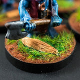 Miniature figure with blue armor and axe on a grassy base