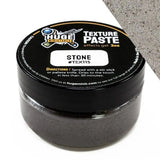 Jar of texture paste with black lid and gray paste inside, on a white background.