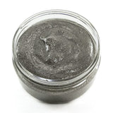 Jar of dark gray膏体 on a white background