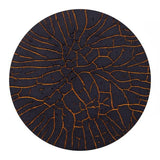 Round black coaster with orange tree branch pattern on a white background