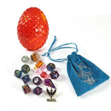 Collection of dice and gaming accessories including a red dragon egg, dice set, and blue drawstring bag on a white background.