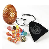 Collection of dice and a dragon egg-shaped container on a white background