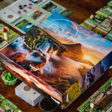 Board game box titled 'Earth' with scenic design on a wooden table