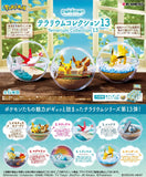 Pokémon Terrarium Collection 13 with three small figurines in glass bubbles on a wooden surface.