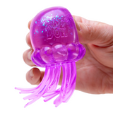Purple jellyfish-shaped toy held in a hand against a white background