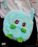 Turquoise fluffy bag with cartoonish face design worn by a person