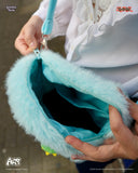 Close-up of a turquoise bag with fluffy texture held by a person wearing a white outfit.