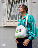 Person wearing a green striped shirt with a fluffy white creature plush toy over their shoulder.