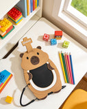 Children's desk with a bear-shaped phone, colorful blocks, and pencils near a window.