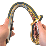 Decorative curved sword held by two hands on a white background