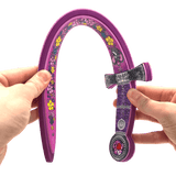 Purple decorative horseshoe held by two hands on a transparent background