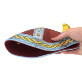 Hand holding a decorative sandal with intricate patterns on a white background