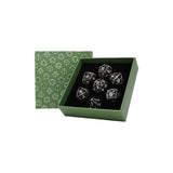 Set of clear dice with black numbers in a green box with geometric pattern