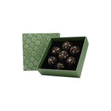 Set of dice with metallic sheen in a green box with dice pattern