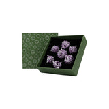 Green jewelry box with purple jewelry items on a white background