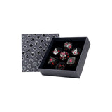 Set of dice with red and silver details in a black box with geometric pattern